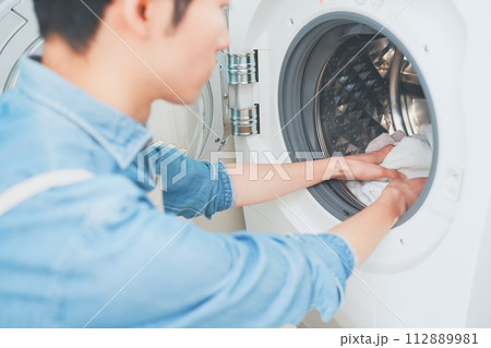 洗濯をするエプロン姿の男性 洗濯をするエプロン姿の男性 112889981