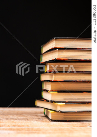 Stack of old books on a black background. Wisdom and knowledge, love of reading. Stack of old books on a black background. Wisdom and knowledge, love of reading. 112890053