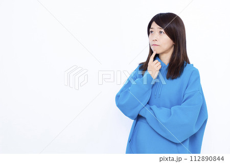 真剣に悩んでいる青いパーカーを着た女性 真剣に悩んでいる青いパーカーを着た女性 112890844