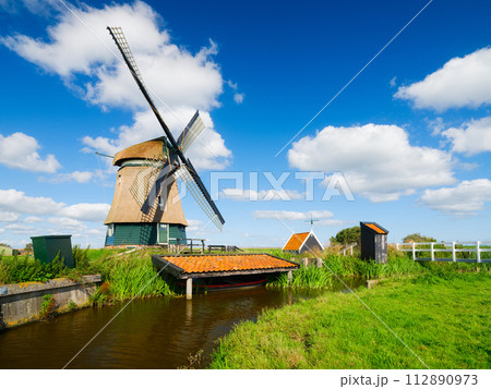 An old mill in the Netherlands. Historical building. A mill near a canal. 112890973
