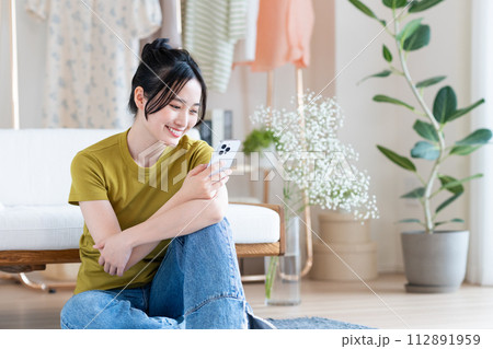 リビングでスマホを見る若い女性 リビングでスマホを見る若い女性 112891959