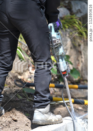 ハツリ工事　ハンマードリルでコンクリートブロックを斫る作業員 112893616