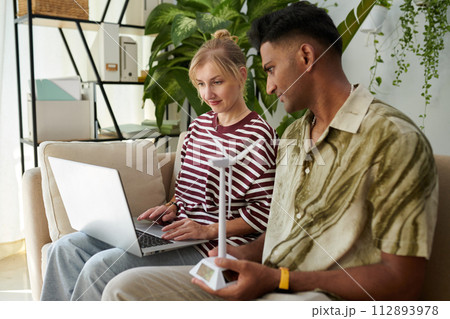 Small business owners watching video on wind turbine power generation Small business owners watching video on wind turbine power generation 112893978