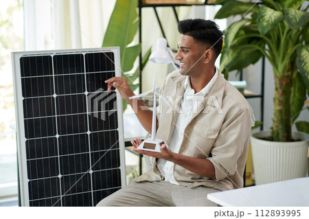 Cheerful sustainability engineer talking about difference between solar power and wind power Cheerful sustainability engineer talking about difference between solar power and wind power 112893995