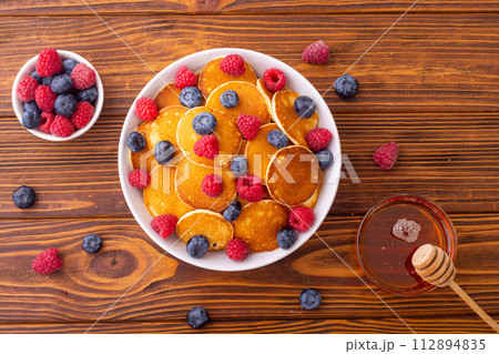 Mini pancakes with berries . Delicious breakfast . 112894835