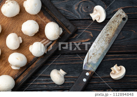 Many raw mushroom champignon  on wooden background 112894848