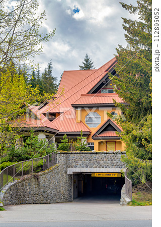 Garage entrance of luxurious residential building with big roof 112895052