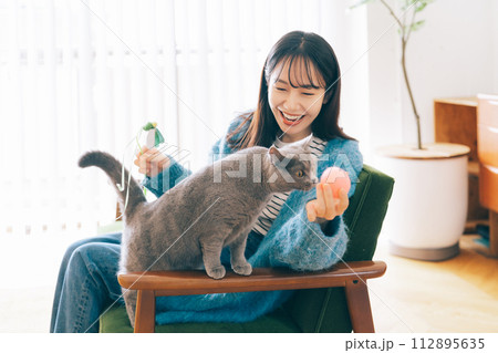 自宅で猫と遊ぶ女性 自宅で猫と遊ぶ女性 112895635