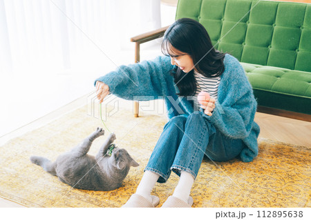 自宅で猫と遊ぶ女性 自宅で猫と遊ぶ女性 112895638