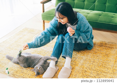 自宅で猫と遊ぶ女性 112895641