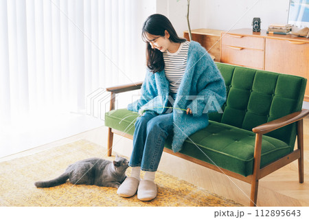 自宅で猫と遊ぶ女性 112895643