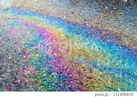 Leaked Gasoline Oil Slick or Petrol Rainbow Enviromental leak On Tarmac Road 112896630
