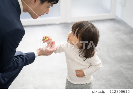 出勤時に父親へプレゼントを渡す子供 出勤時に父親へプレゼントを渡す子供 112896636