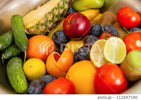 Fruits, vegetables and greens lie on the table, natural light 112897580