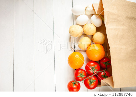 Paper bag on a wooden background, vegetables from the store 112897740
