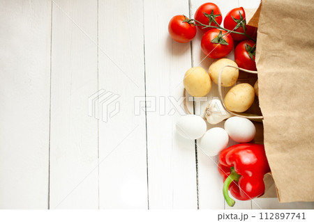 Paper bag on a wooden background, vegetables from the store 112897741