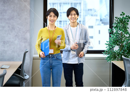 オフィスでスマホを操作する女性ITエンジニア オフィスでスマホを操作する女性ITエンジニア 112897848