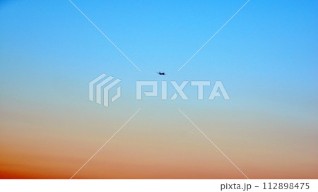 日没前の空に飛び立つ飛行機 112898475