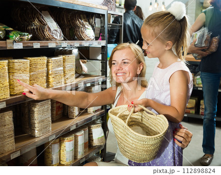 Mother with daughter buy corn cakes in store Mother with daughter buy corn cakes in store 112898824