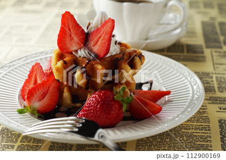 べルギーワッフルと苺(あまおう)にチョコレートソースをかけてコーヒーと一緒に 112900169