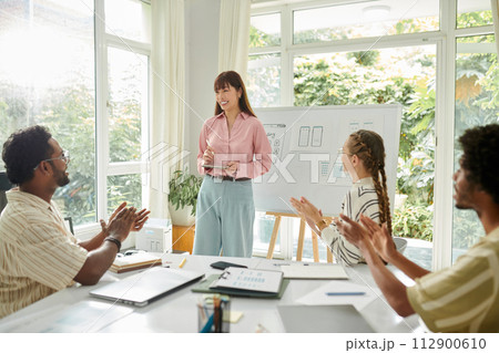 Team members applauding to UI designer after her project presentation 112900610