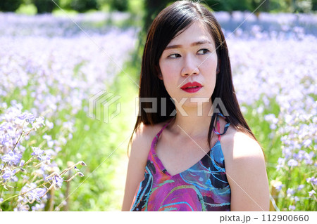 Beautiful Asian woman is tried and hot in blooming purple Murdannia giganteum flowers field 112900660