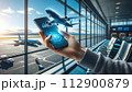 A hand holds a phone displaying a 3D airplane hologram, 112900879