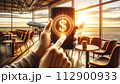 A hand holds a mobile phone with a simple 3D dollar coin hologram floating outside 112900933