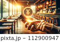 a hand holds a phone with a floating 3D yen coin hologram 112900947
