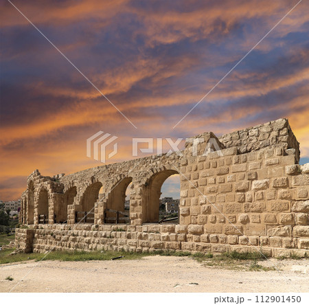 Roman ruins (against the background of a beautiful sky with clouds) in the Jordanian city of Jerash (Gerasa of Antiquity), capital and largest city of Jerash Governorate, Jordan 112901450