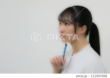 スケジュールの打ち合わせをするスーツ姿の女性 考えるしぐさ スケジュールの打ち合わせをするスーツ姿の女性 考えるしぐさ 112902066