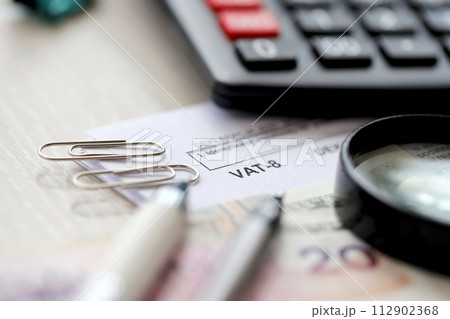 Declaration for tax on goods and services VAT-8 form on accountant table with pen and polish zloty money bills close up Declaration for tax on goods and services VAT-8 form on accountant table with pen and polish zloty money bills close up 112902368