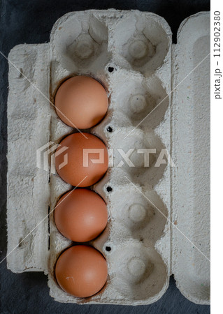 Fresh chicken eggs in a paper tray on the table, selective focus Fresh chicken eggs in a paper tray on the table, selective focus 112902380