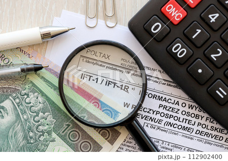 Information on revenue income derived by nonresident natural persons IFT-1, IFT-1R form on accountant table with pen and polish zloty money bills close up 112902400