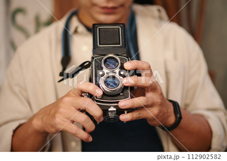 Creative man taking photos with old camera of his father 112902582