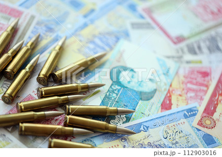 Many bullets and iranian rials money bills close up. Concept of terrorism funding or financial operations to support war in Iran Many bullets and iranian rials money bills close up. Concept of terrorism funding or financial operations to support war in Iran 112903016