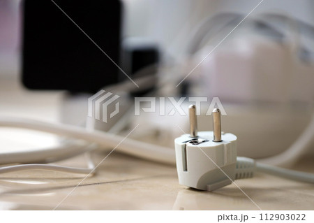 Overloaded power boards. Power strips with different electrical plugs on white floor. Concept of risk danger overloaded current electrical 112903022