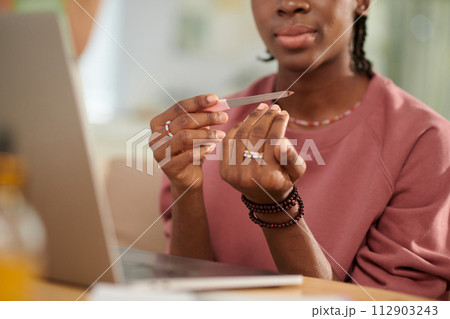 Closeup image of teenage Black girl filing nails Closeup image of teenage Black girl filing nails 112903243