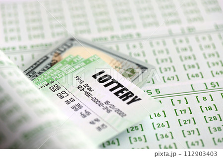 Green lottery tickets and US money bills on blank with numbers for playing lottery close up Green lottery tickets and US money bills on blank with numbers for playing lottery close up 112903403