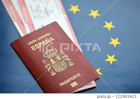 Red Spanish passport of European Union with airline tickets on blue background close up. Tourism and travel concept Red Spanish passport of European Union with airline tickets on blue background close up. Tourism and travel concept 112903423