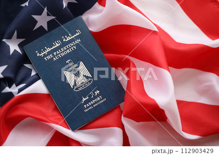 Blue Palestinian Authority passport on United States national flag background close up. Tourism and diplomacy concept Blue Palestinian Authority passport on United States national flag background close up. Tourism and diplomacy concept 112903429
