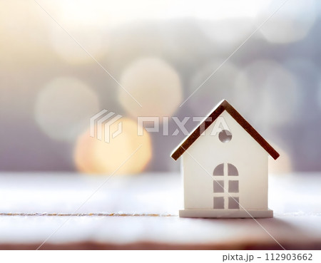 Miniature house is a symbol of mortgage and home ownership on blurred background. 112903662