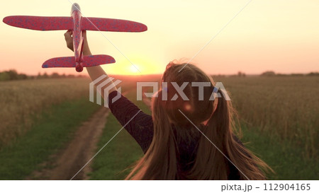 girl plays countryside toy airplane, girl hair flutters wind while running airplane sunset, child holds airplane hand sunset, dreams flying, kid child girl daughter runs with toy airplane hand park. girl plays countryside toy airplane, girl hair flutters wind while running airplane sunset, child holds airplane hand sunset, dreams flying, kid child girl daughter runs with toy airplane hand park. 112904165