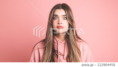 Amazed female model with wide open eyes over pink background 112904458
