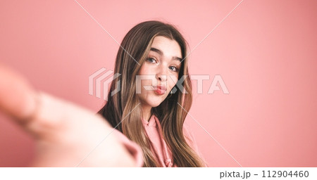 Pretty woman puckering lips in pink studio 112904460