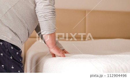 Gay couple getting the sheets right and making the bed in the morning 112904496