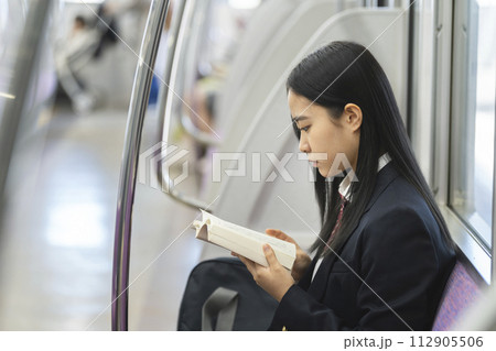 電車の中で本を読む女子高校生 電車の中で本を読む女子高校生 112905506
