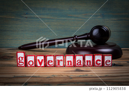 GOVERNANCE. Red alphabet letters and judge's gavel on wooden background. Laws and justice concept GOVERNANCE. Red alphabet letters and judge's gavel on wooden background. Laws and justice concept 112905838