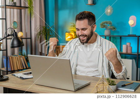 Business man working on laptop netbook shocked by sudden victory celebrate win good career news 112906628