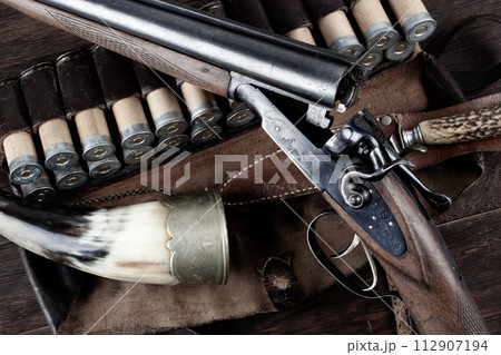double barreled side shotgun with cartridges in bandolier. double barreled side shotgun with cartridges in bandolier. 112907194